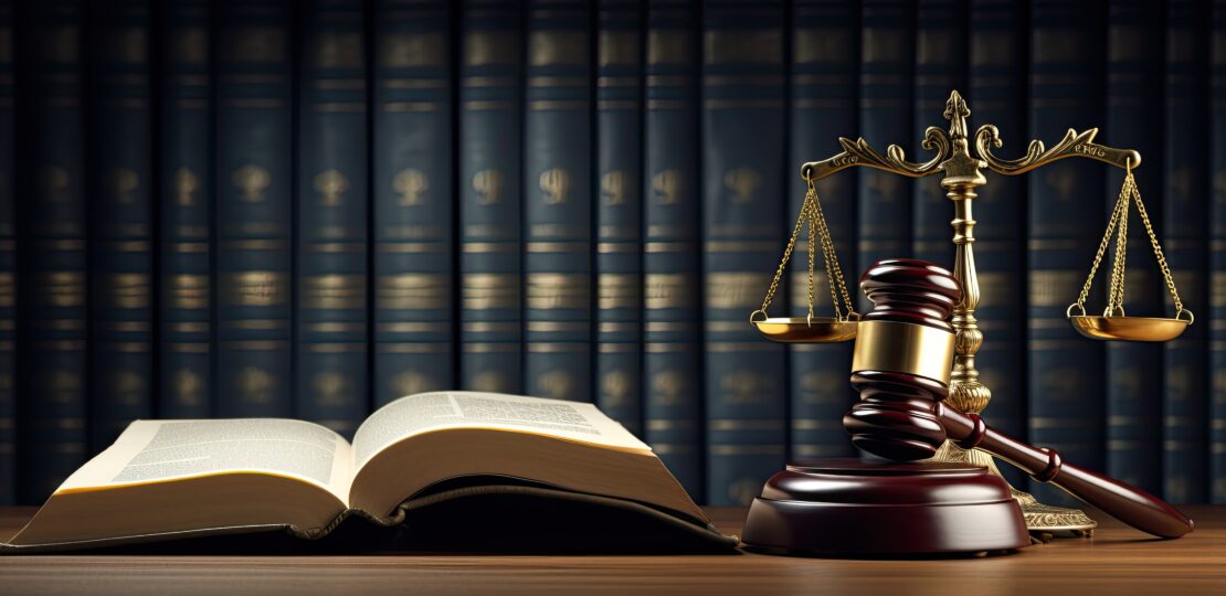 Legal Law and Justice concept Open law book with a wooden judges gavel in a courtroom or law enforcement office